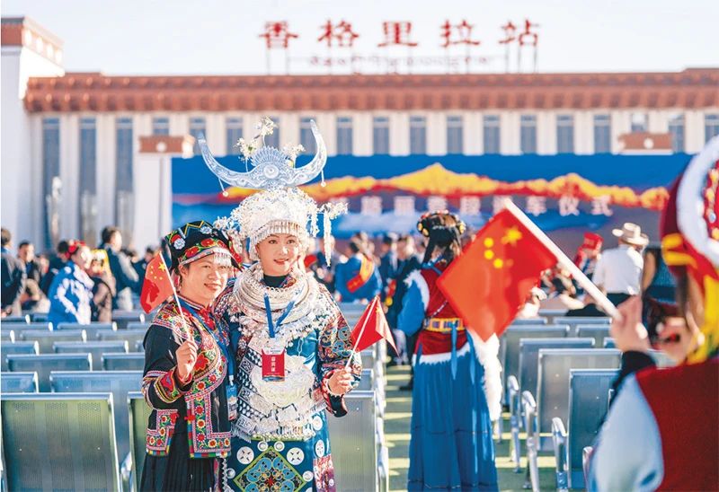 2023年11月26日，麗江至香格里拉鐵路開通運營。麗香鐵路起自云南省麗江市玉龍納西族自治縣麗江站，接入云南省迪慶藏族自治州香格里拉市香格里拉站，穿越青藏高原橫斷山區腹地，途經多個民族聚集地。圖為麗香鐵路開通當日，參加通車儀式的少數民族代表拍照留念。 新華社記者 陳欣波/攝
