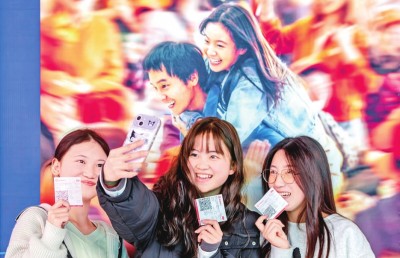 2月18日，觀眾在貴州省黔西市一家影院的電影海報前留影。 新華社發