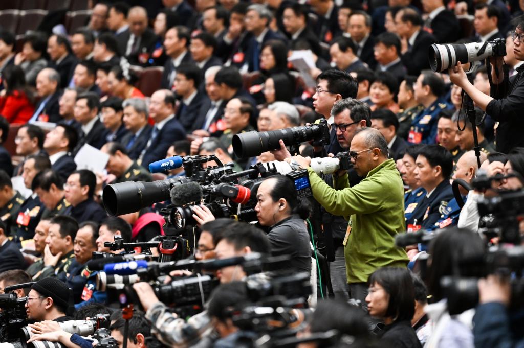 3月8日，十四屆全國人大二次會議在北京人民大會堂舉行第二次全體會議。這是記者在會議現場采訪。新華社記者 牟宇 攝