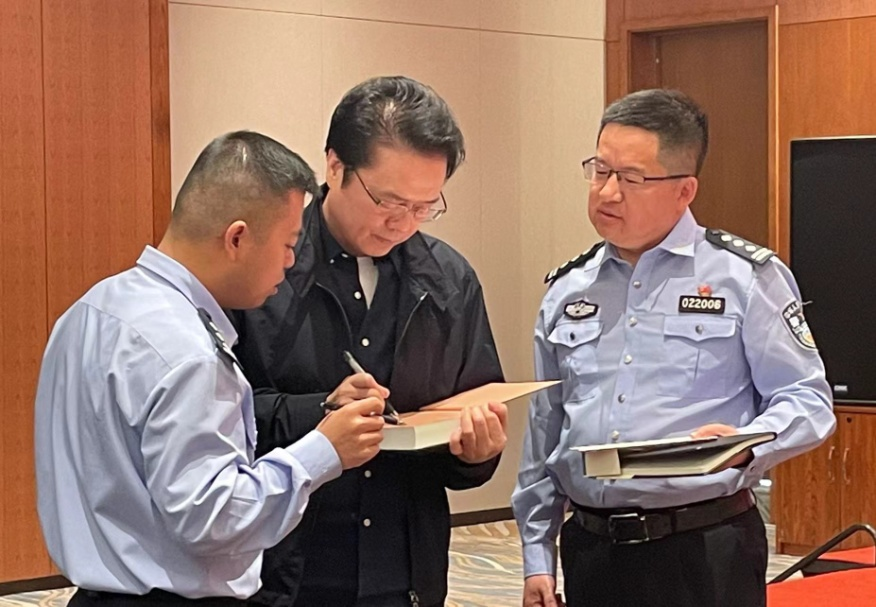 活動期間，陳彥（圖中）在給警營作家簽名。