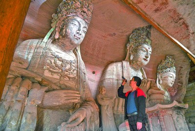 義務文保員在對重慶市大足區寶頂鎮香山社區的佛祖巖摩崖造像進行巡查。新華社記者 王全超攝