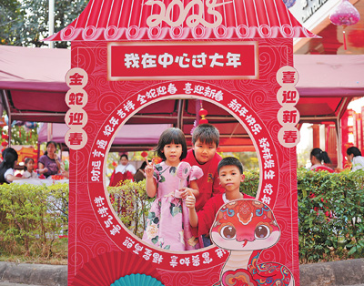 老撾民眾在“歡樂春節”廟會現場設立的新春祈福打卡點拍照。  坎帕頌攝
